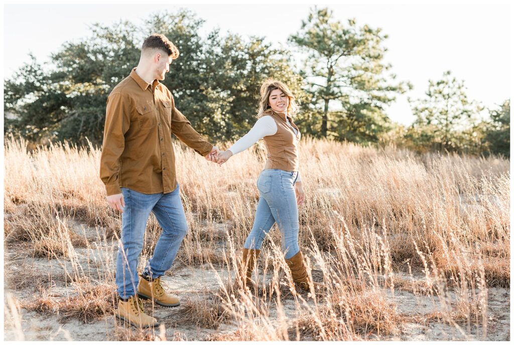 couple walking in fall engagement session at Brock Enviornmental center by michael and jasmine photography