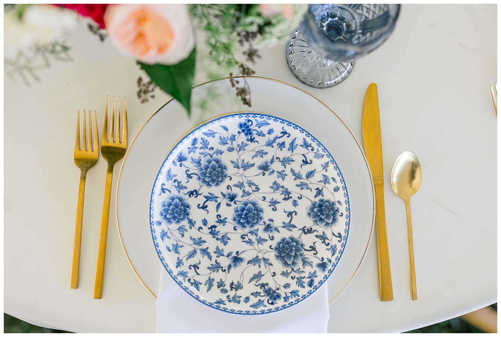 reception place settings blue and white plate with gold flatware