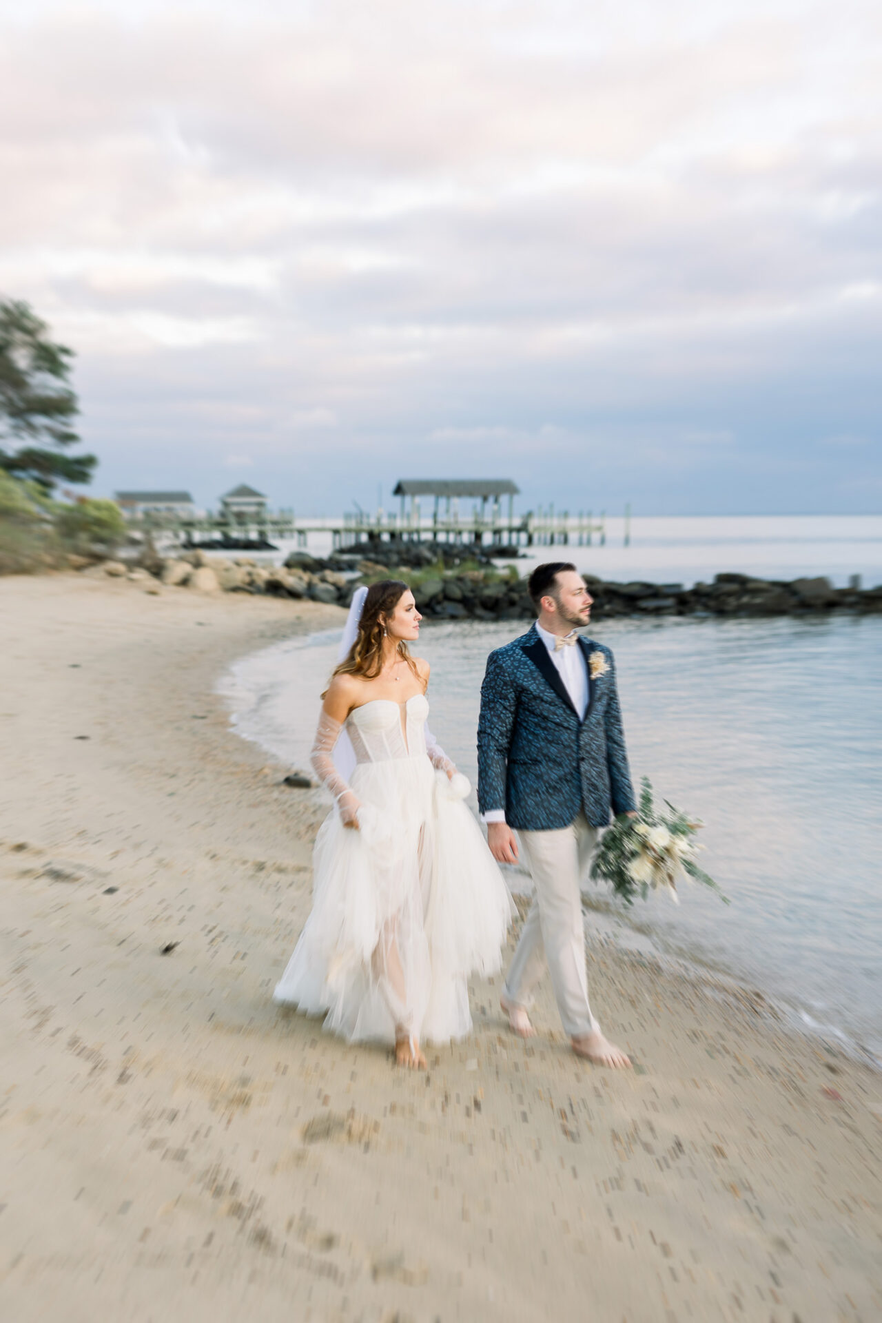 bride and groom walking on beach of James River Country Club
