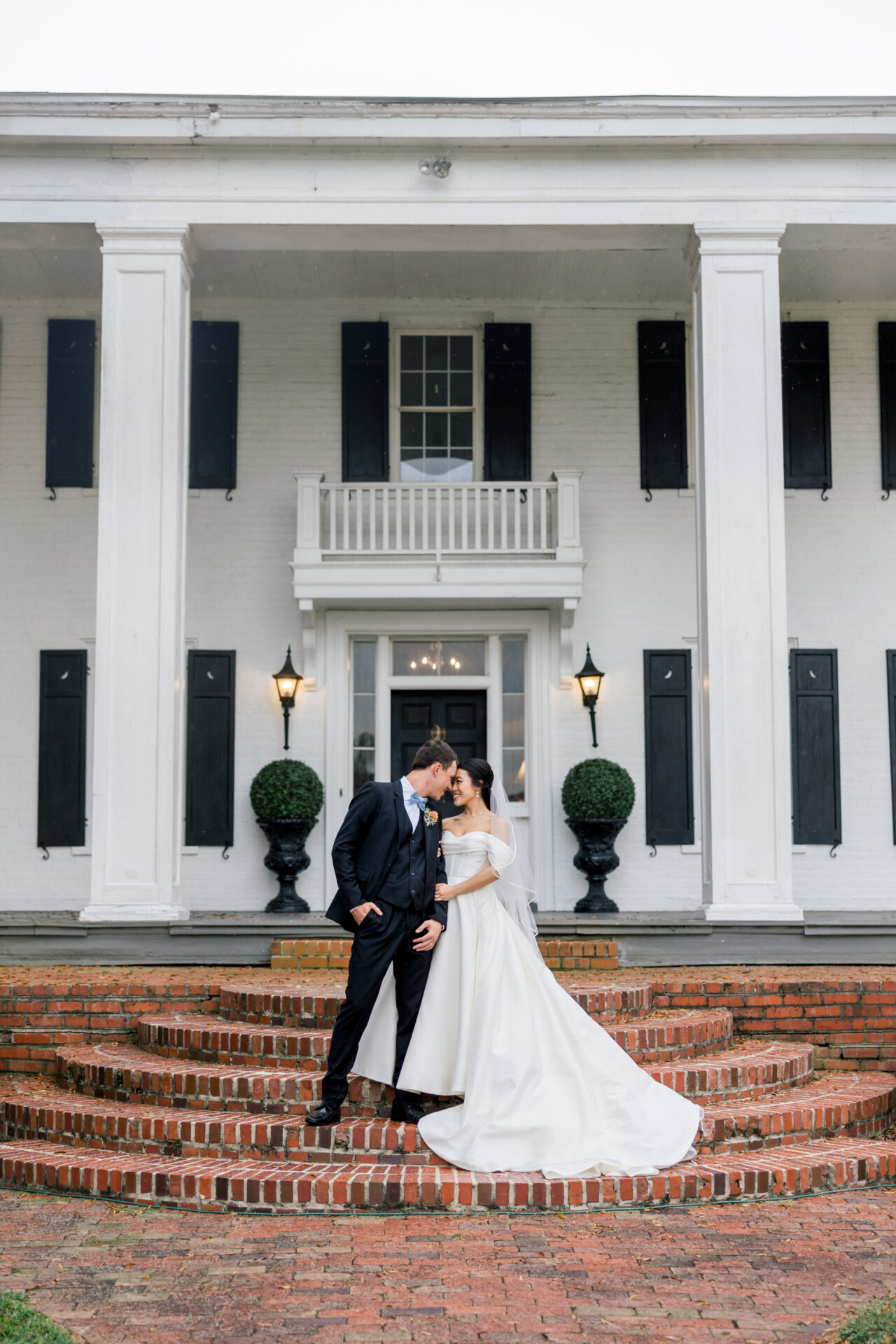 Bride and groom on steps of Hollyfield Manor fall wedding