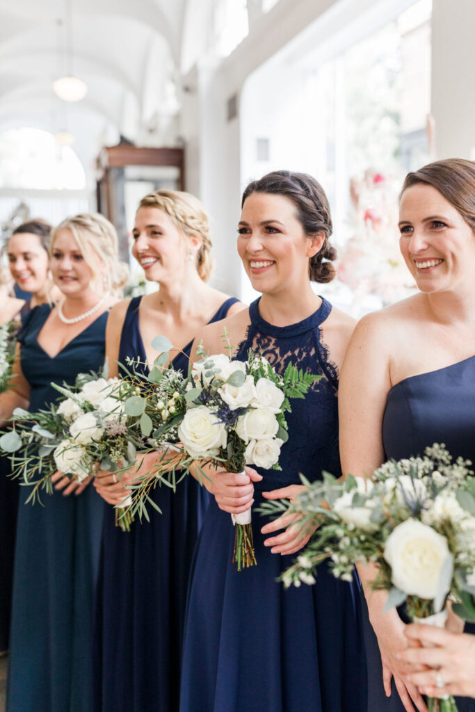 bridesmaids in navy blue dress holding bouquets at Quirk Hotel Richmond