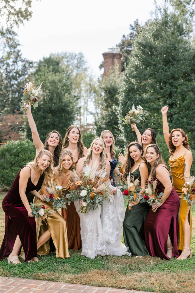 bride and bridesmaids smile and cheer for photo outside Seven Springs Richmond VA wedding