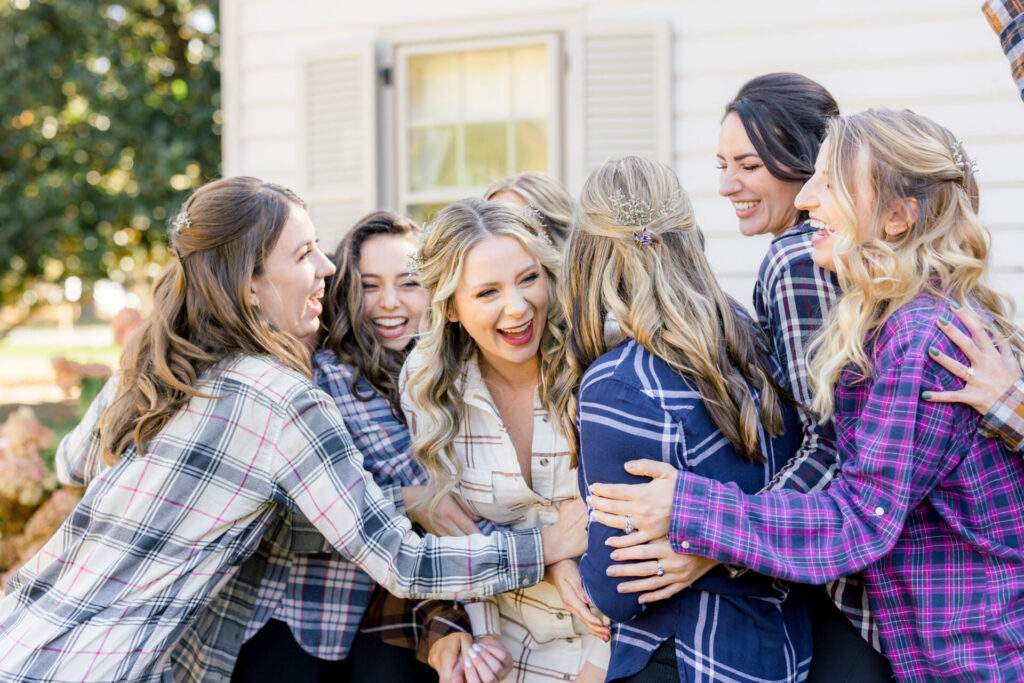 bride and bridesmaids laughing in flannel pajama photo outside Seven Springs Richmond Va Wedding