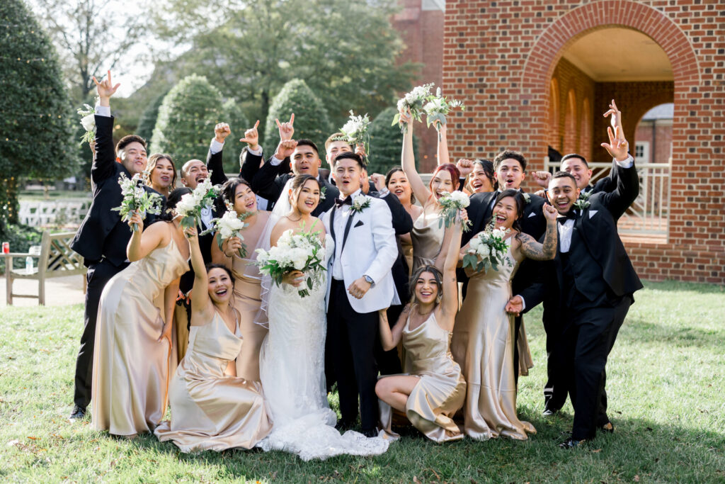 wedding party cheering for photos outside Founders Inn Wedding Virginia Beach
