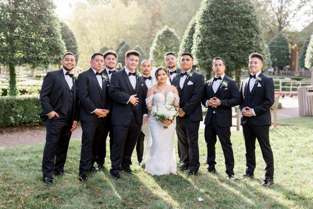 bride taking a photo with groomsmen outside Founders Inn Wedding Virginia Beach